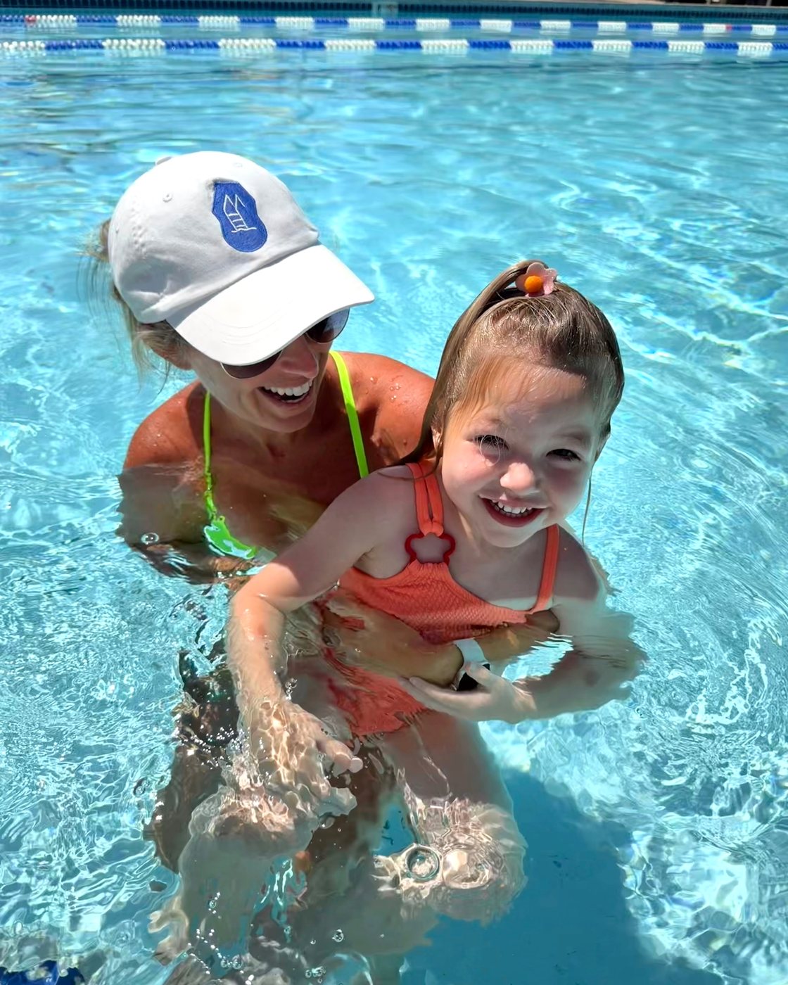 Caitlin MacDougald smiling in the pool with a young student during a private self-rescue swim lesson